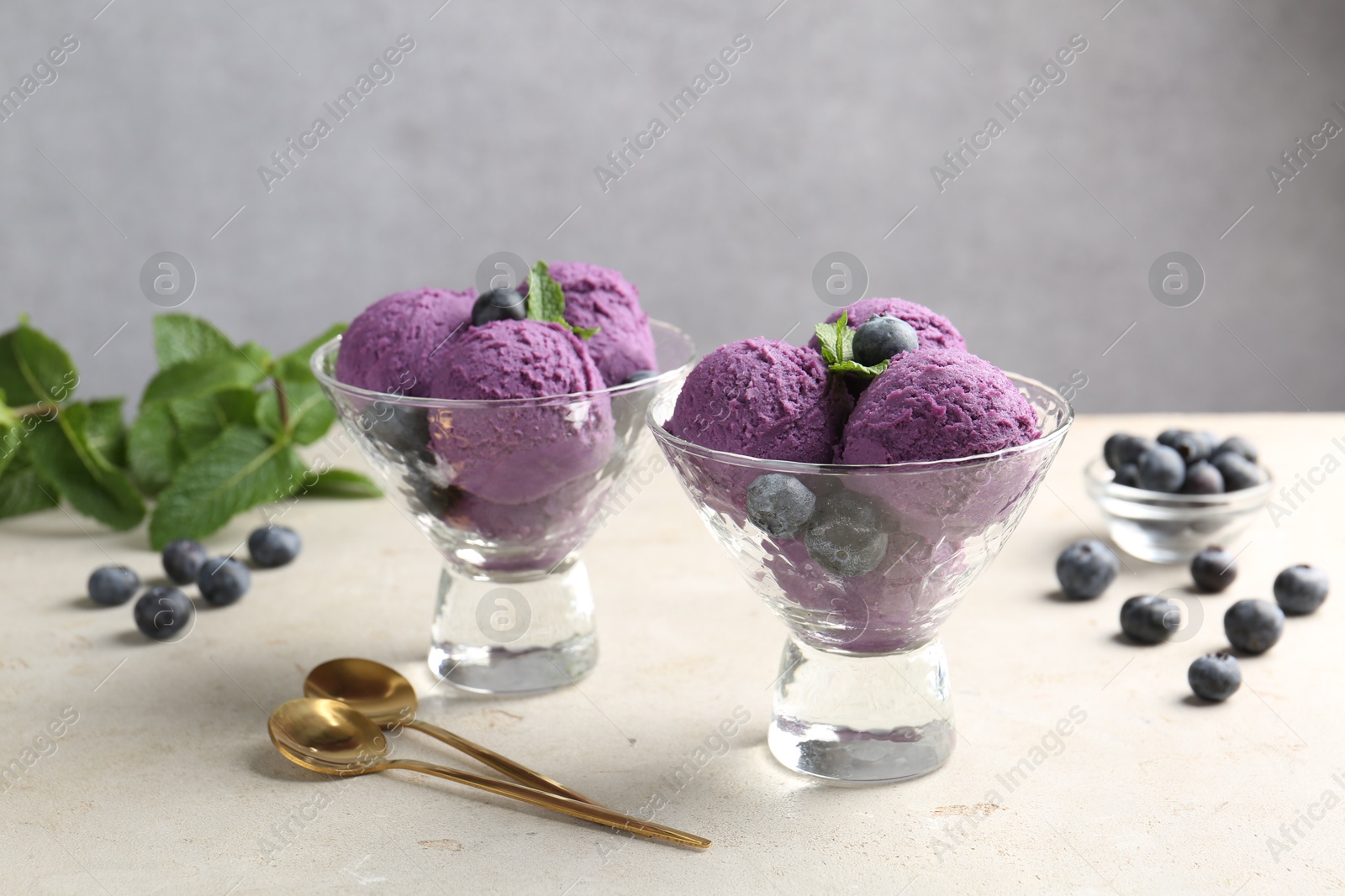 Tasty sorbet with blueberries and mint on light grey table Photo of Tasty sorbet with blueberries and mint on light grey table