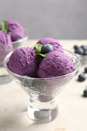 Photo of Tasty sorbet with blueberries and mint on light grey table, closeup