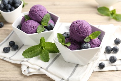 Photo of Tasty sorbet with blueberries and mint on wooden table, closeup