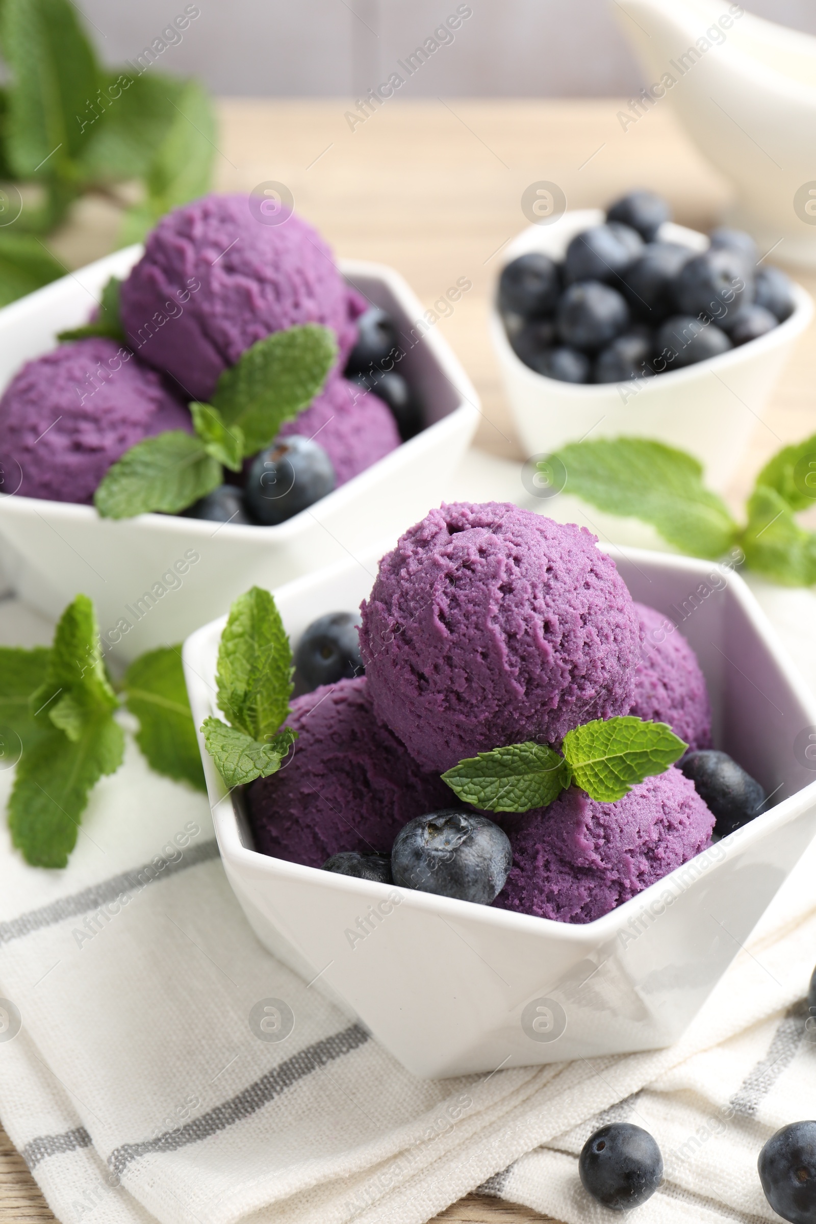 Photo of Tasty sorbet with blueberries and mint on table, closeup