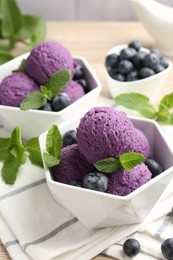 Photo of Tasty sorbet with blueberries and mint on table, closeup