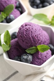 Photo of Tasty sorbet with blueberries and mint on table, closeup