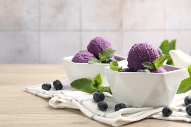 Photo of Tasty sorbet with blueberries and mint on wooden table, closeup. Space for text