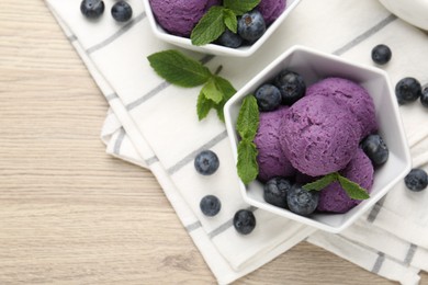 Photo of Tasty sorbet with blueberries and mint on wooden table, flat lay. Space for text