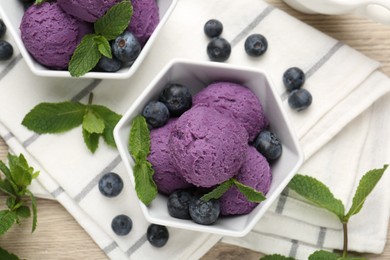 Photo of Tasty sorbet with blueberries and mint on wooden table, flat lay