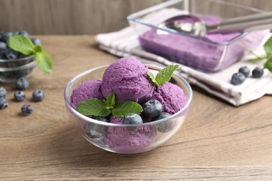 Photo of Tasty sorbet with blueberries and mint on wooden table, closeup