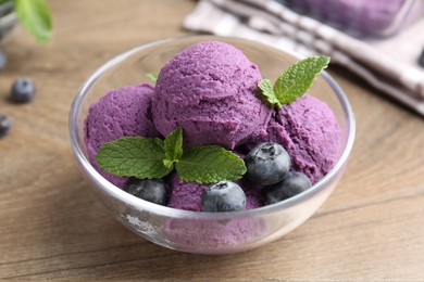 Photo of Tasty sorbet with blueberries and mint on wooden table, closeup