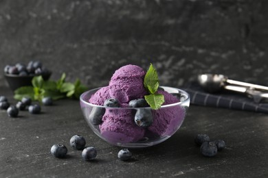 Photo of Tasty sorbet with blueberries and mint on black table, closeup