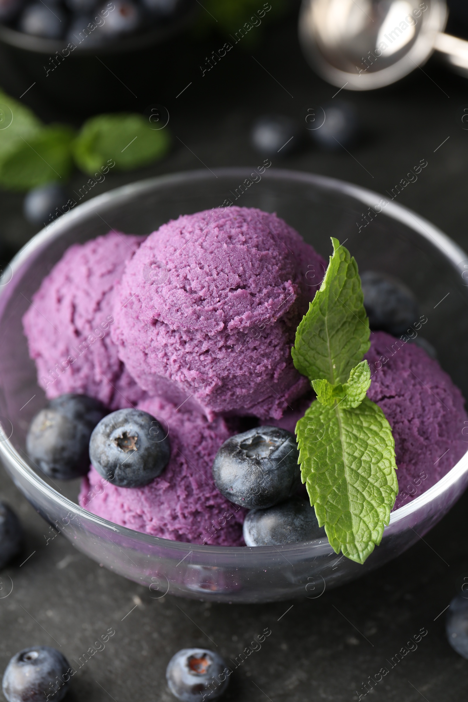 Photo of Tasty sorbet with blueberries and mint on black table, closeup