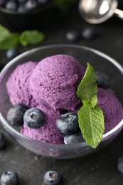 Photo of Tasty sorbet with blueberries and mint on black table, closeup