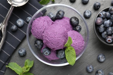 Photo of Tasty sorbet with blueberries and mint on black table, flat lay