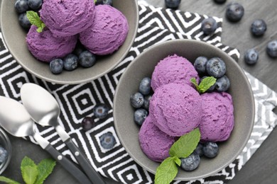 Photo of Tasty sorbet with blueberries and mint on black table, flat lay