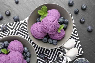 Photo of Tasty sorbet with blueberries and mint on black table, flat lay
