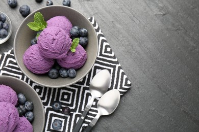 Photo of Tasty sorbet with blueberries and mint on black table, flat lay. Space for text