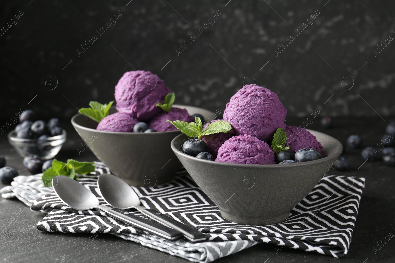 Photo of Tasty sorbet with blueberries and mint on black table, closeup