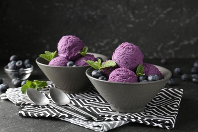 Photo of Tasty sorbet with blueberries and mint on black table, closeup