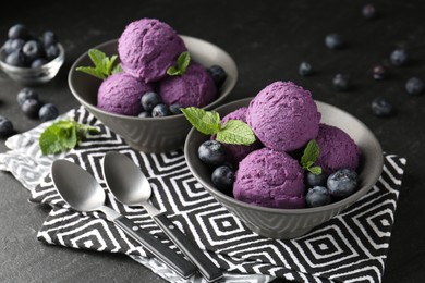 Photo of Tasty sorbet with blueberries and mint on black table, closeup