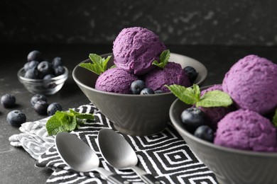 Photo of Tasty sorbet with blueberries and mint on black table, closeup