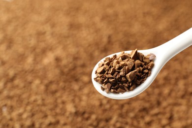 Photo of Spoon with aromatic instant coffee as background, closeup