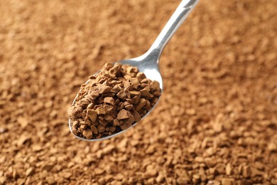 Photo of Spoon with aromatic instant coffee as background, closeup