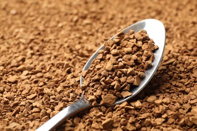 Photo of Spoon with aromatic instant coffee as background, closeup