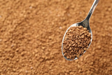 Photo of Spoon with aromatic instant coffee as background, closeup