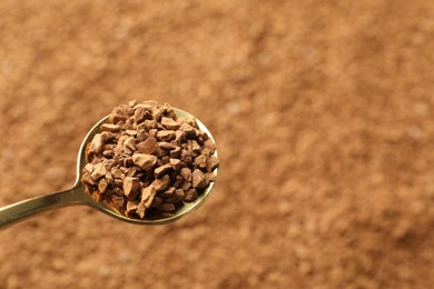 Photo of Spoon with aromatic instant coffee as background, closeup