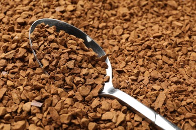 Photo of Spoon with aromatic instant coffee as background, closeup