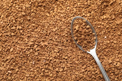 Photo of Spoon with aromatic instant coffee as background, closeup