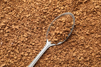 Photo of Spoon with aromatic instant coffee as background, closeup