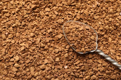 Photo of Spoon with aromatic instant coffee as background, closeup