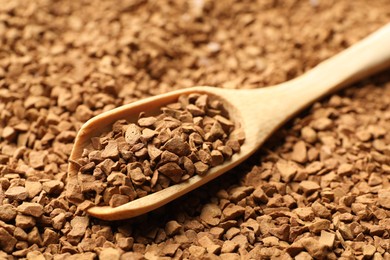 Photo of Spoon with aromatic instant coffee as background, closeup
