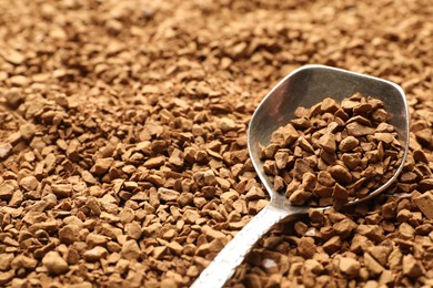 Photo of Spoon with aromatic instant coffee as background, closeup