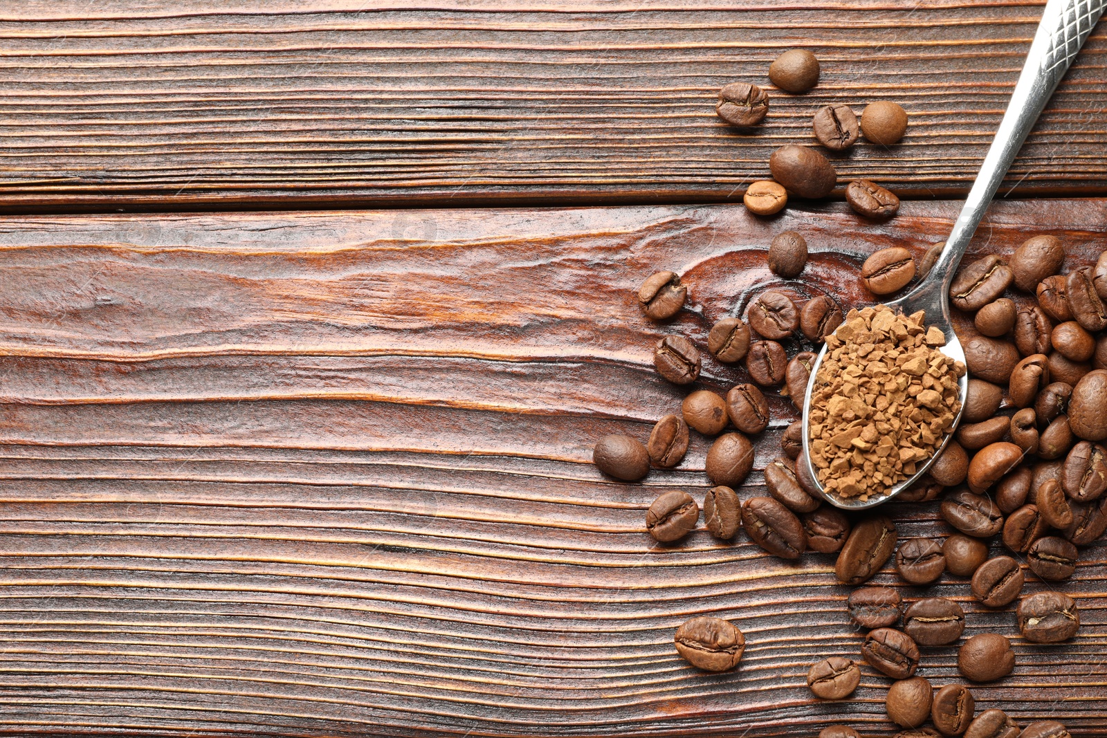 Spoon with instant coffee and beans on wooden table, flat lay. Space for text Photo of Spoon with instant coffee and beans on wooden table, flat lay. Space for text
