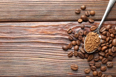 Photo of Spoon with instant coffee and beans on wooden table, flat lay. Space for text