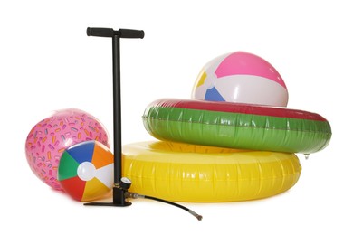 Photo of Inflatable rings, balls and manual air pump isolated on white