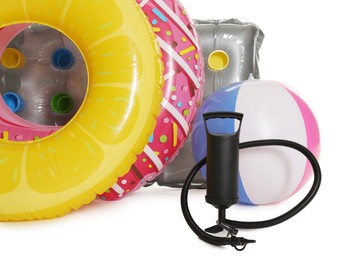 Photo of Inflatable rings, mattress, ball and manual air pump isolated on white