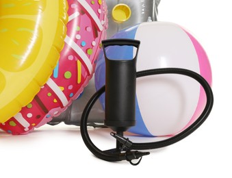 Photo of Inflatable rings, mattress, ball and manual air pump isolated on white