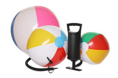 Photo of Inflatable balls and manual air pump isolated on white