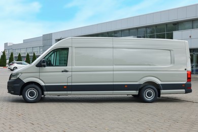 Photo of One white minibus parked on paved road outdoors