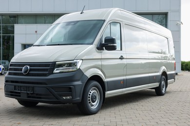 Photo of One white minibus parked on paved road outdoors