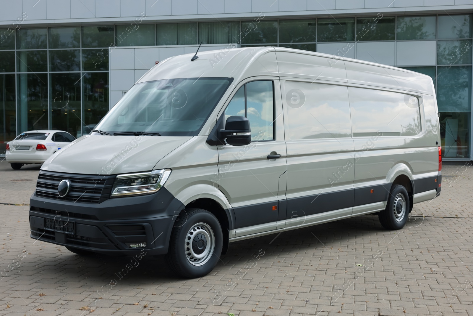 Photo of One white minibus parked on paved road outdoors