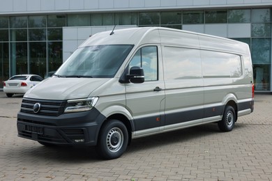 Photo of One white minibus parked on paved road outdoors