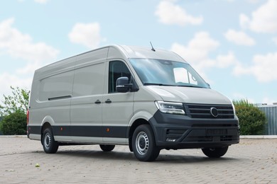 Photo of One white minibus parked on paved road outdoors