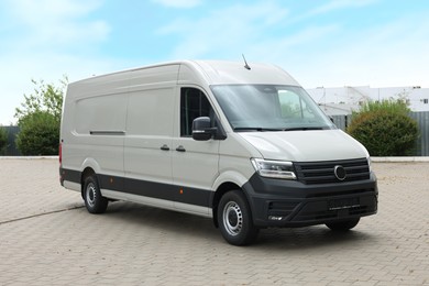 Photo of One white minibus parked on paved road outdoors