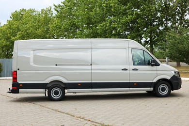 Photo of One white minibus parked on paved road outdoors