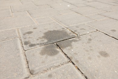 Photo of Stains of motor oil on paved road outdoors, closeup