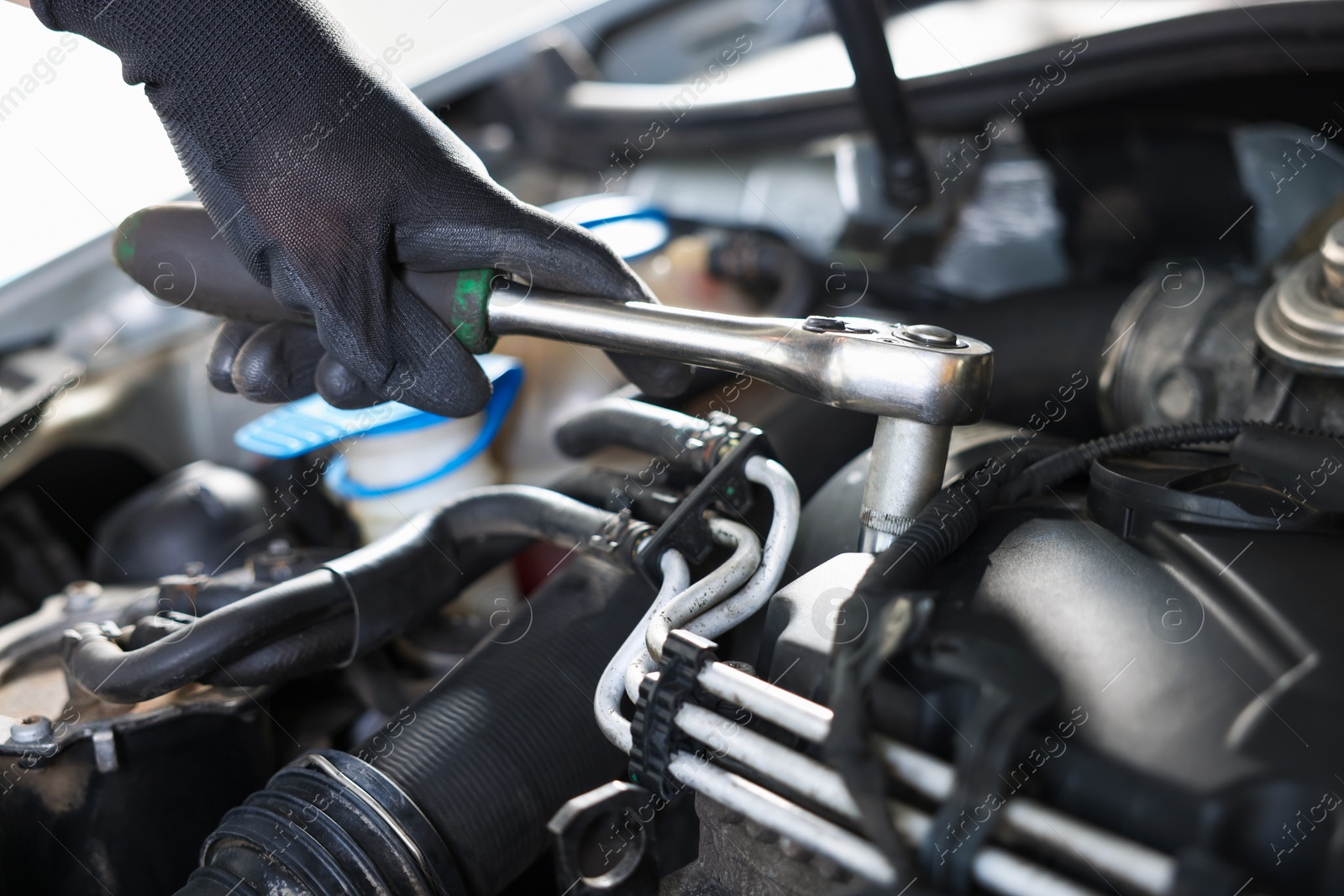 Auto parts. Professional mechanic with torque wrench fixing car indoors, closeup Photo of Auto parts. Professional mechanic with torque wrench fixing car indoors, closeup