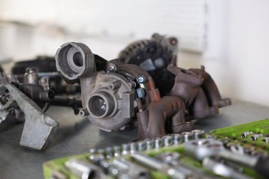 Photo of Different auto parts and tools on grey table indoors, closeup