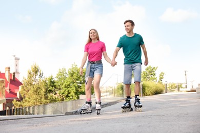 Photo of Happy couple roller skating together on street